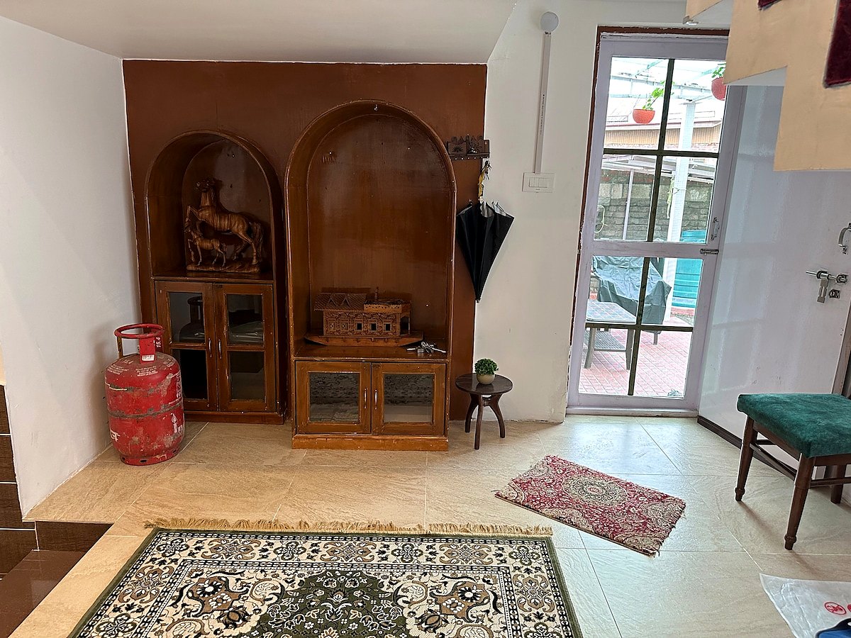 Entry foyer at Chinar House with carved cabinet and front door